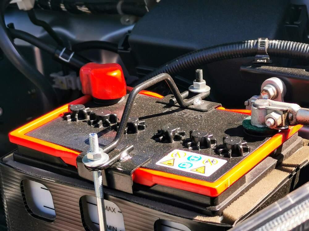 Nærbilde av et bilbatteri festet i motorkassen